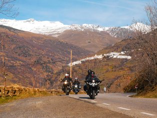Grupo de motos de Hispania Tours frente a un pueblo blanco de la Alpujarra 