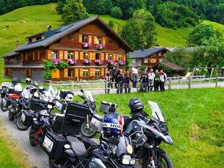 Motorräder vor einem Bauernhof in den Alpen