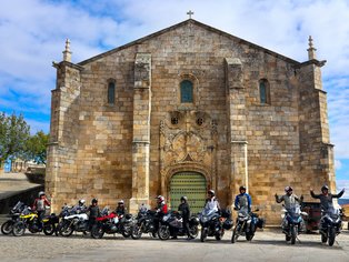 Motorcycle group in front of historical building in Portugal
