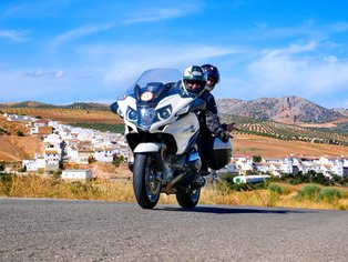 Motorista delante de un pueblo blanco en Andalucía