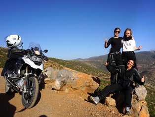 Group of women in front of a motorcycle in the atlas mountains