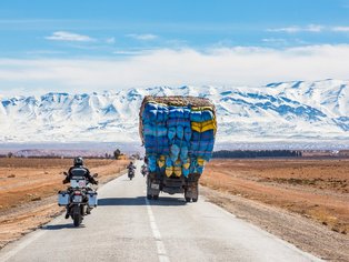 Motorradfahrer vor schneebedecktem Atlas Gebirge